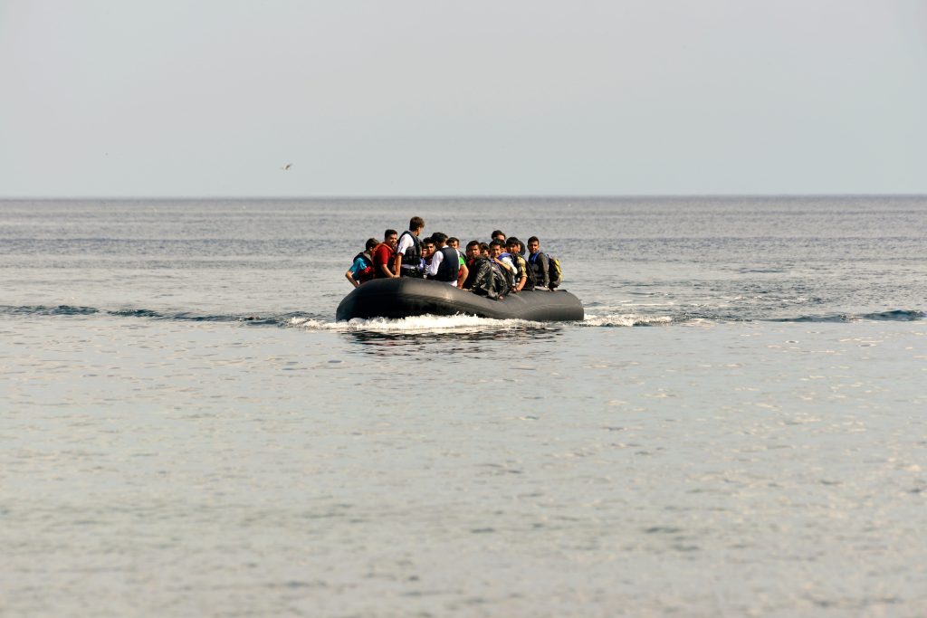 Politica migratoria UE - IP | Diario Digital XXI Crowded inflatable boat with many people wearing life jackets at sea the open ocean ahead.